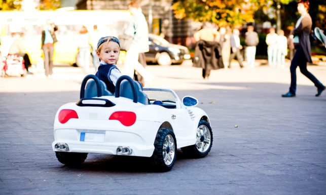 child driving a toy car